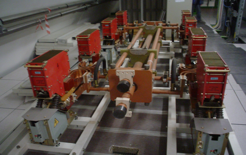 A 13 kA energy extraction system in the LHC tunnel: two symmetric banks of red dump resistors either side of a central copper busbar assembly.